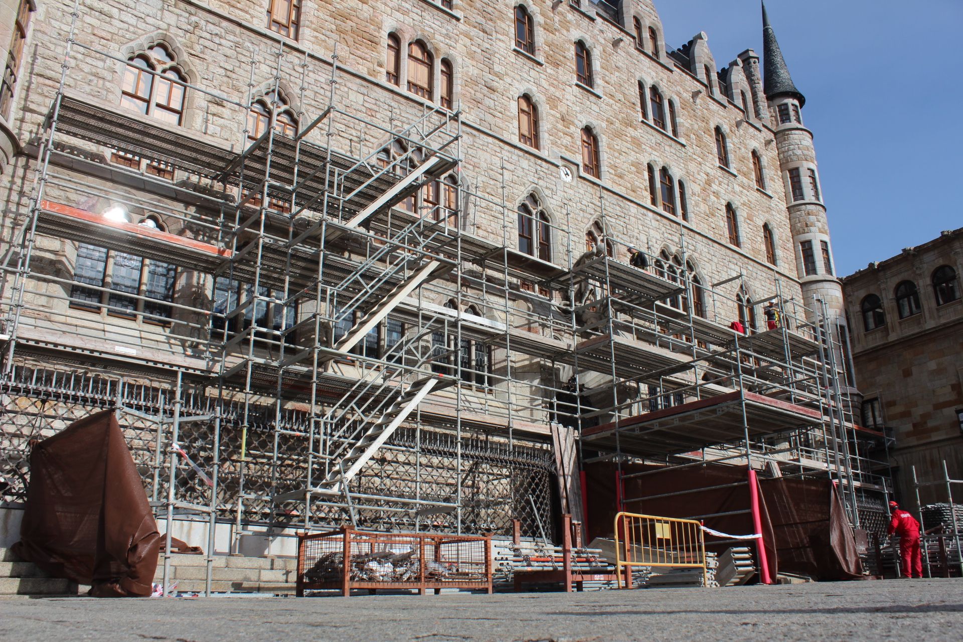 Operarios de obra montando los andamios que esconderán la restauración de la Casa Botines de Gaudí