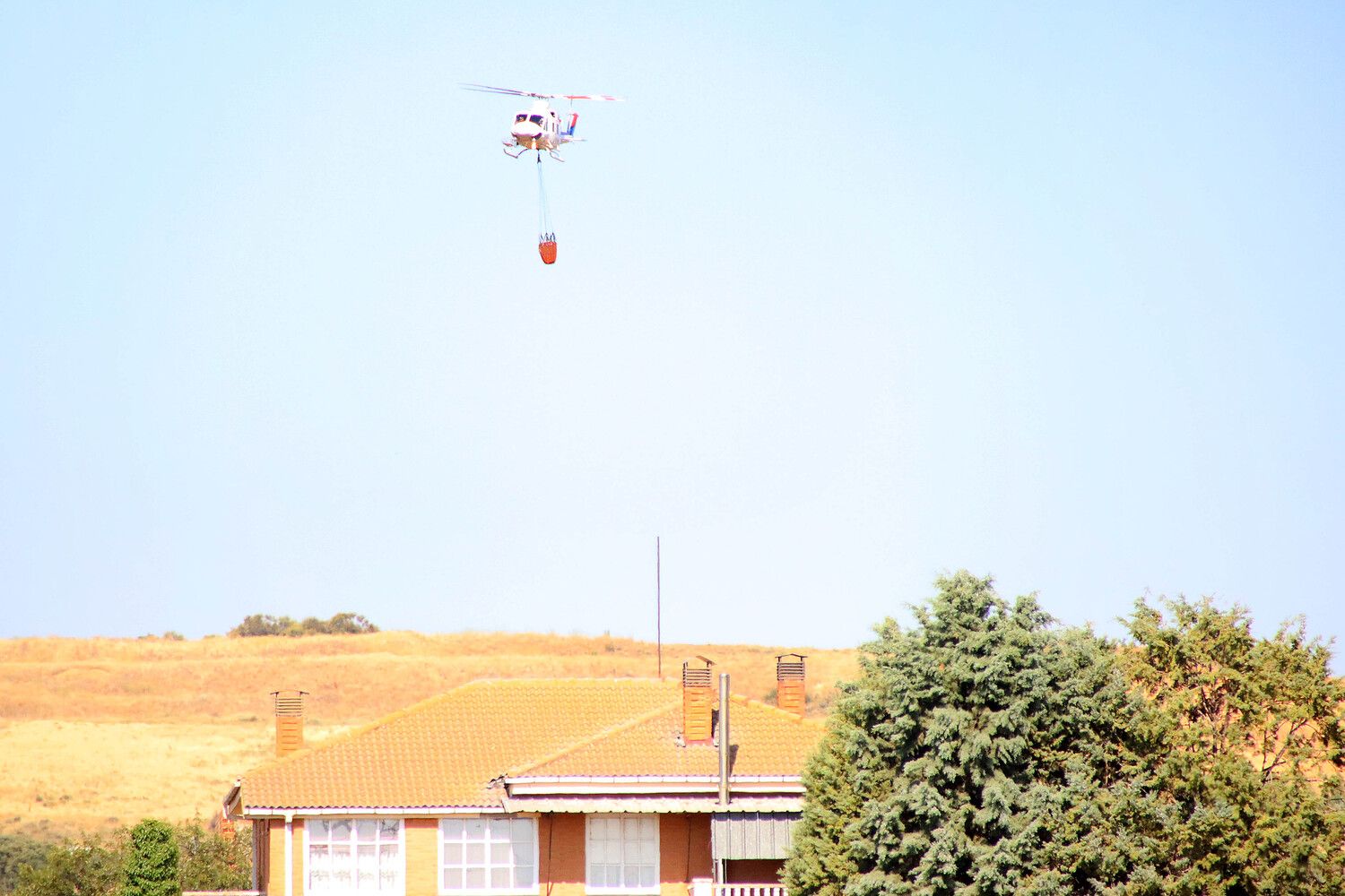 Medios aéreos y terrestres tratan de extinguir un incendio originado en un coche abandonado en Santa Olaja de la Ribera (León)