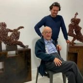 Alejandro Vargas (sentado)  junto con el también escultor Amancio González (de pie) en la galería Ármaga| Fotografía: Marga Carnero / Galería Ármaga