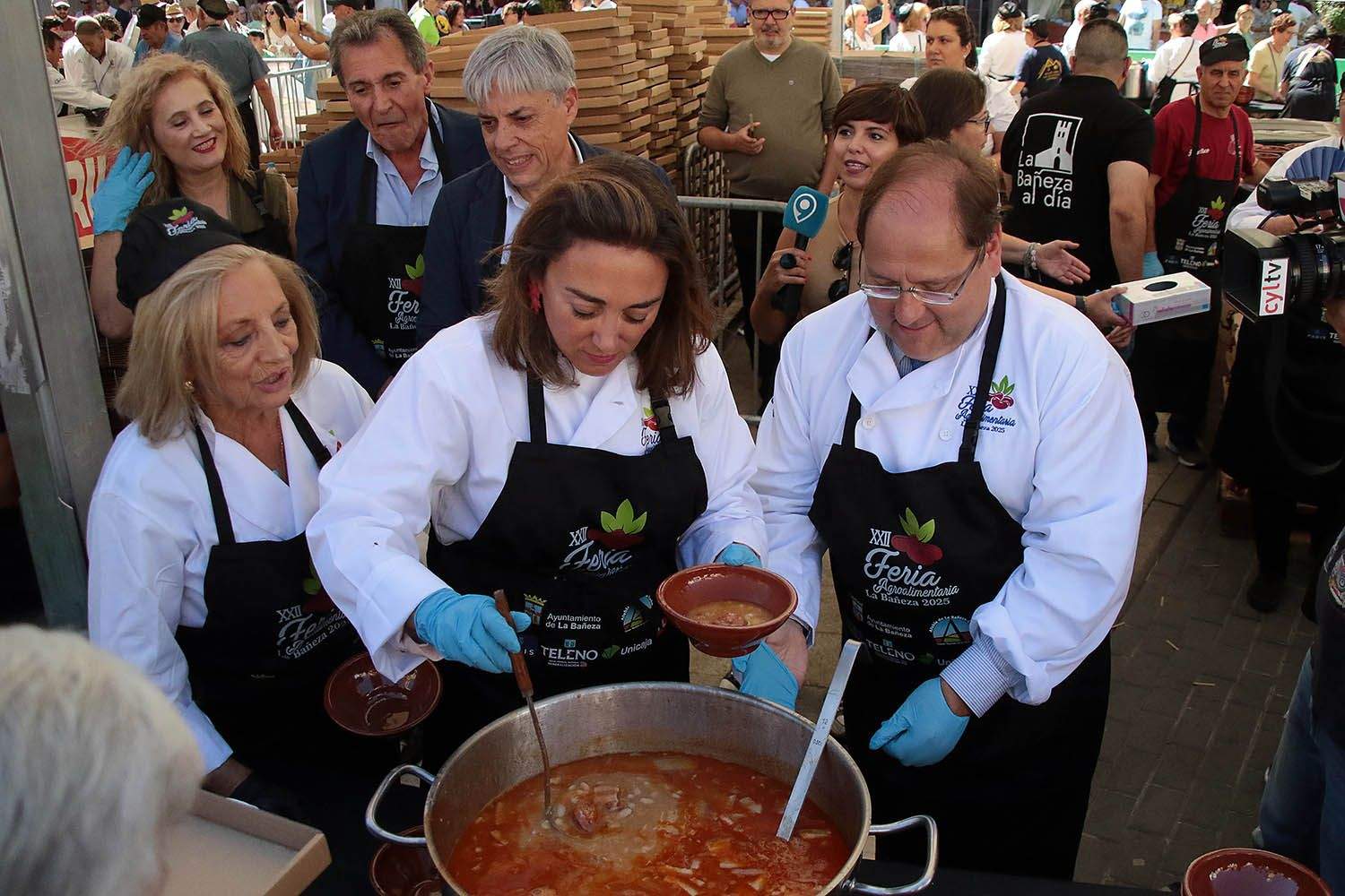 Peio GarcíaICAL. La consejera de Agricultura, Ganadería y Desarrollo Rural, María González Corral, sirve raciones de alubias acompañada por el alcalde, Javier Carrera.