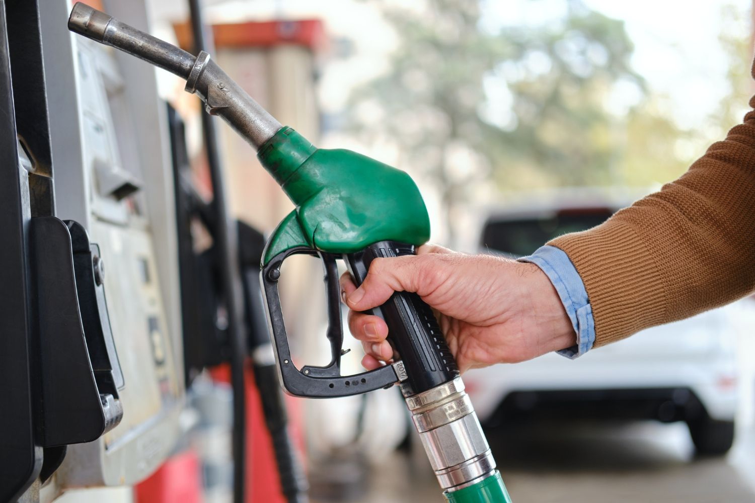 Un hombre repostando en una gasolinera | IStock - Lemon Photo